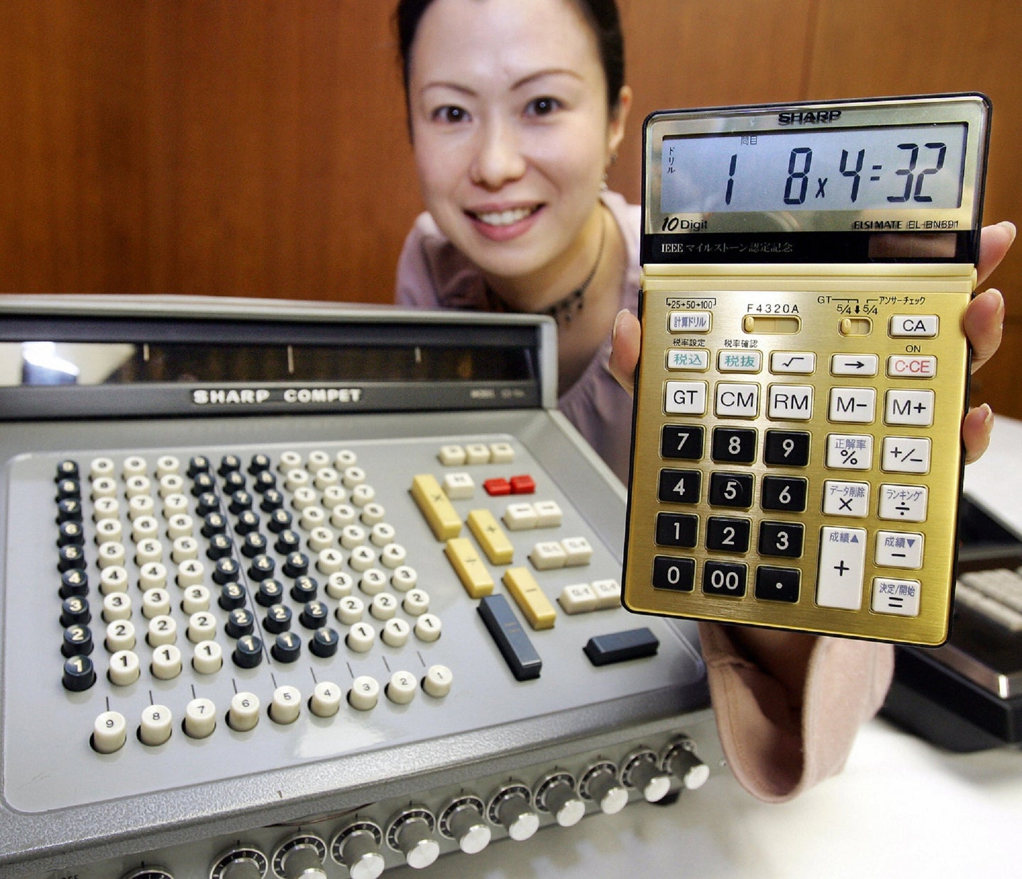 Japanese woman holding gold Sharp calculator with transistor