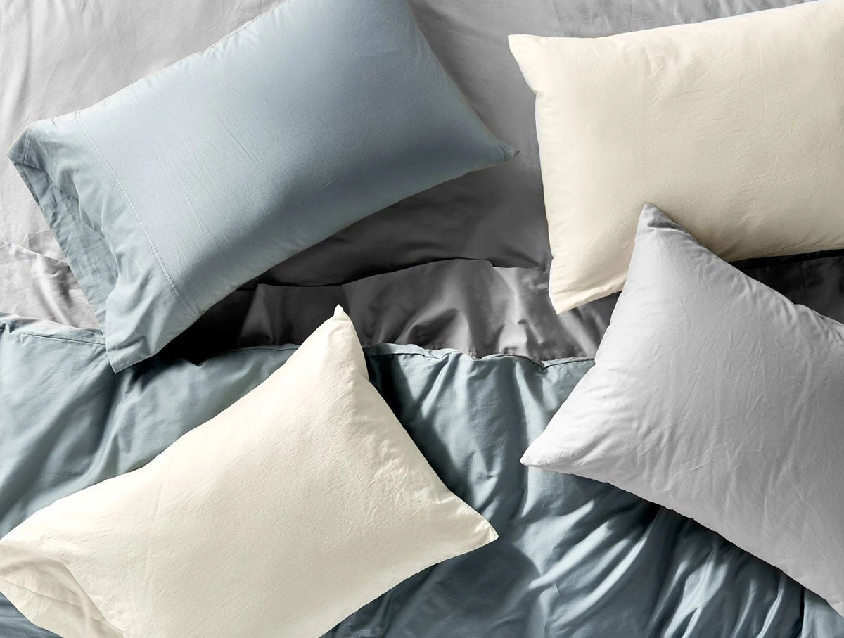 A mix of sheets and pillows in various shades of blues