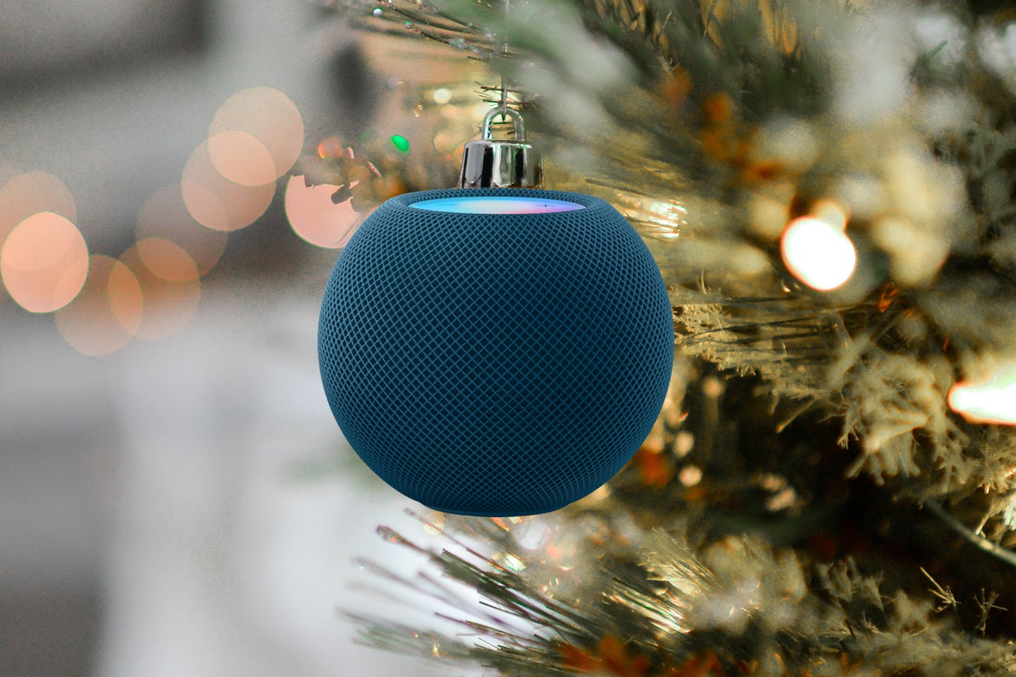 An Apple HomePod Mini as a holiday ornament hanging from the tree