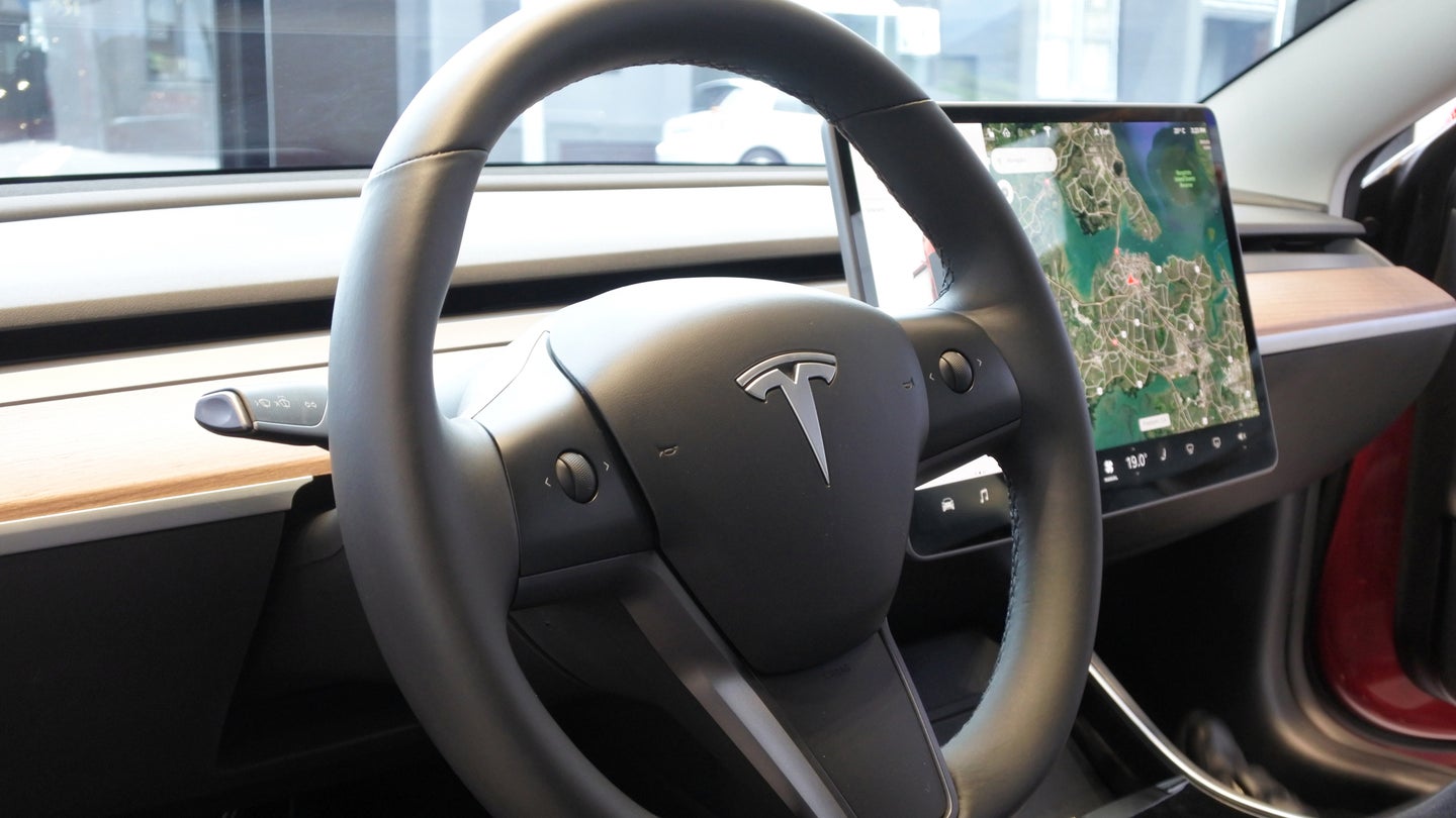 The insignia of Tesla on the steering wheel of the plug-in electric car Model 3