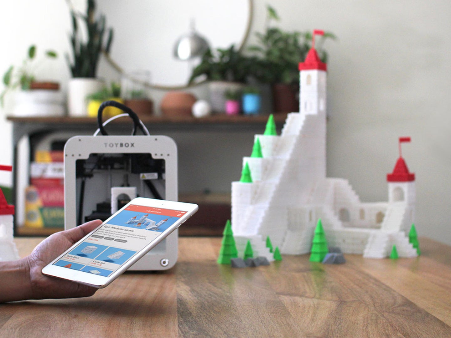 A person uses their smartphone to control their 3D printer
