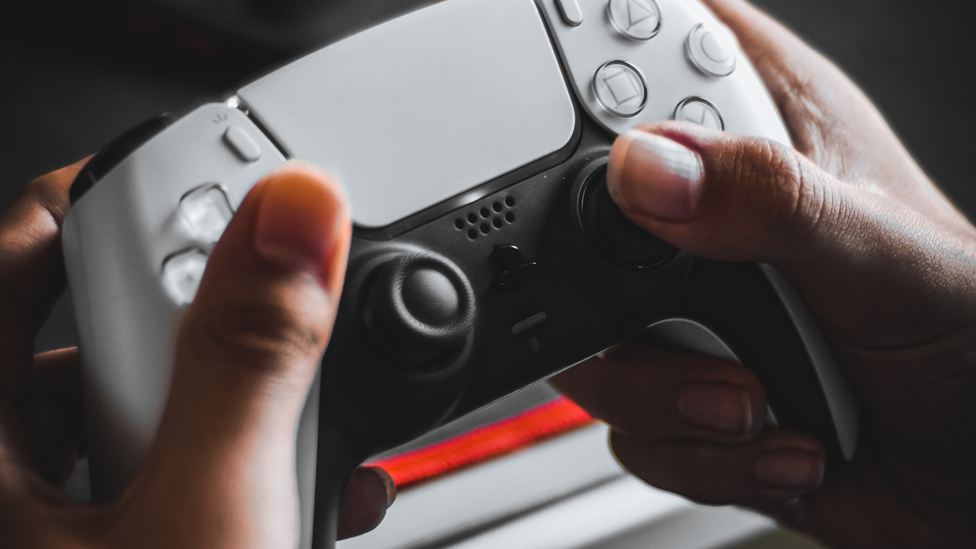 Close up to hands holding a Playstation 5 controller