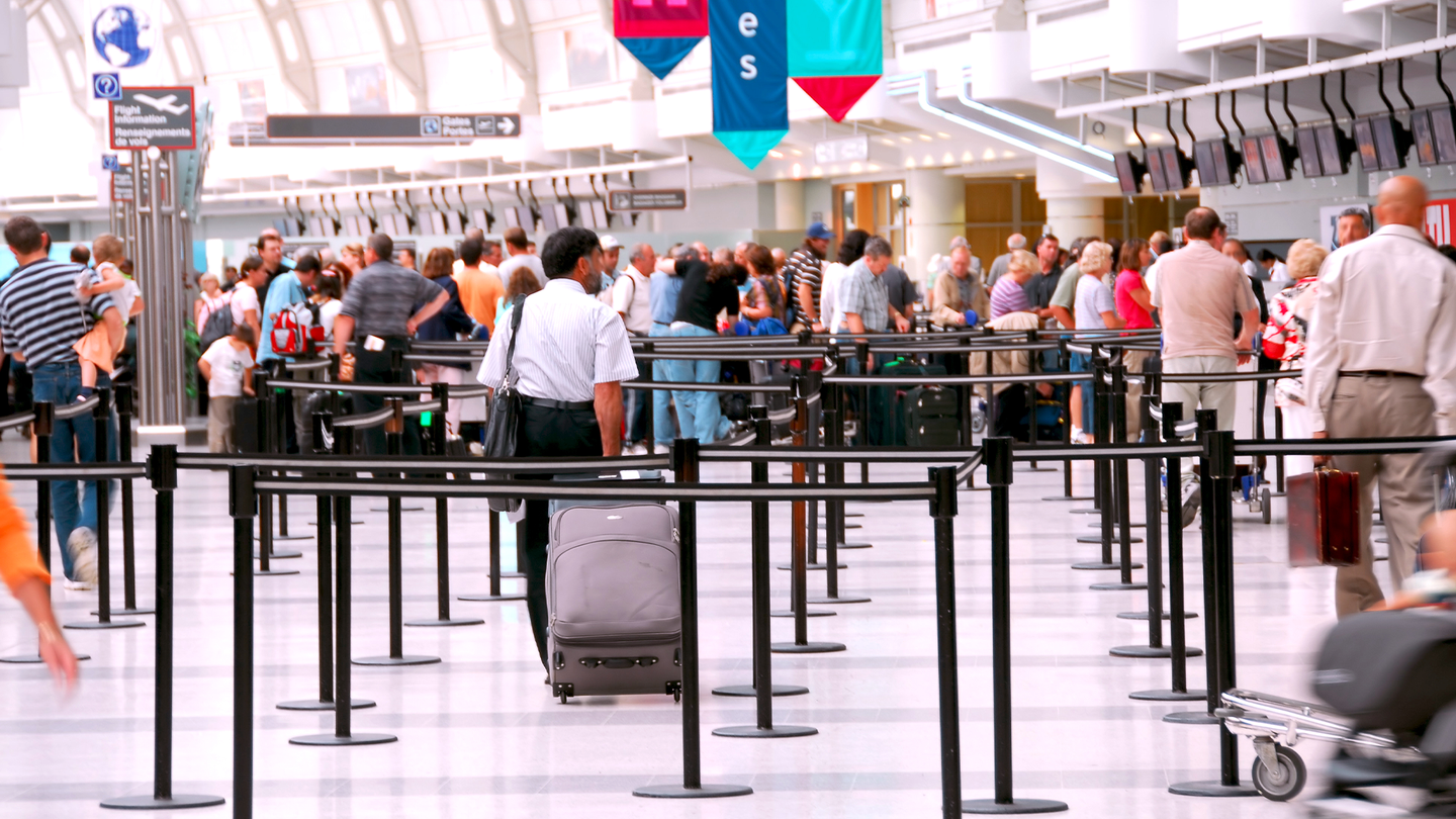 A crowded airport ticket line