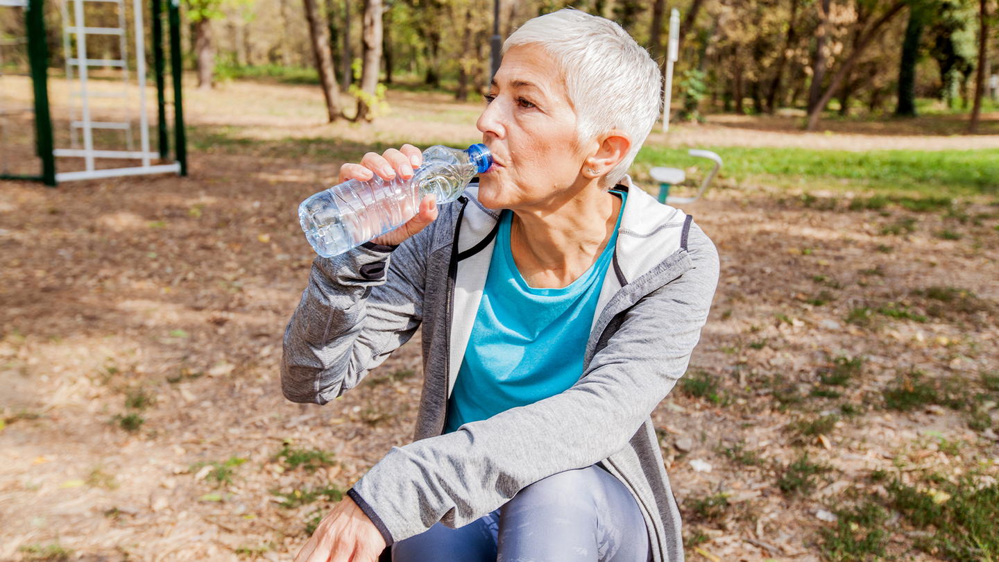 A woman drinking water after a work out.