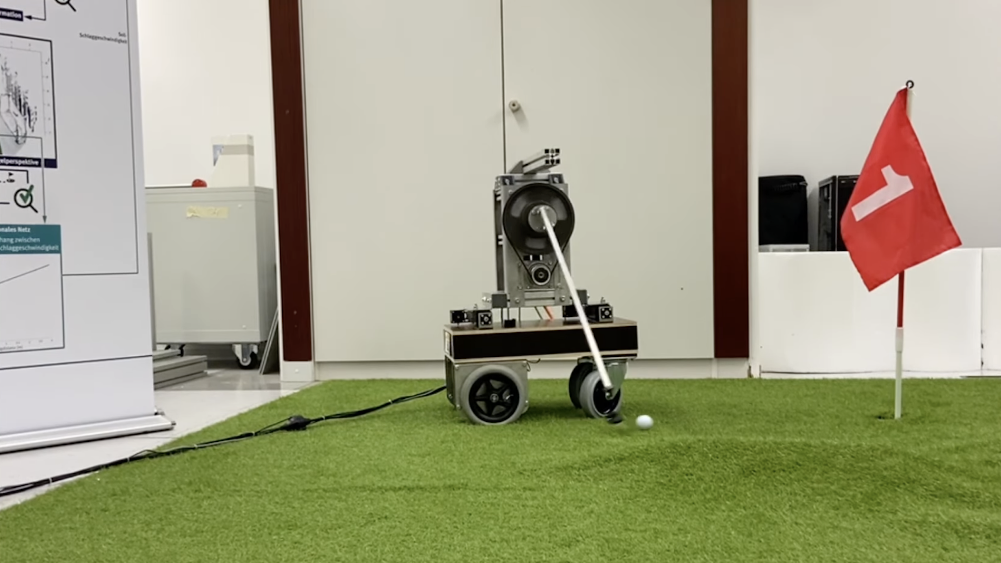 Robot putting golf ball across indoor field into hole