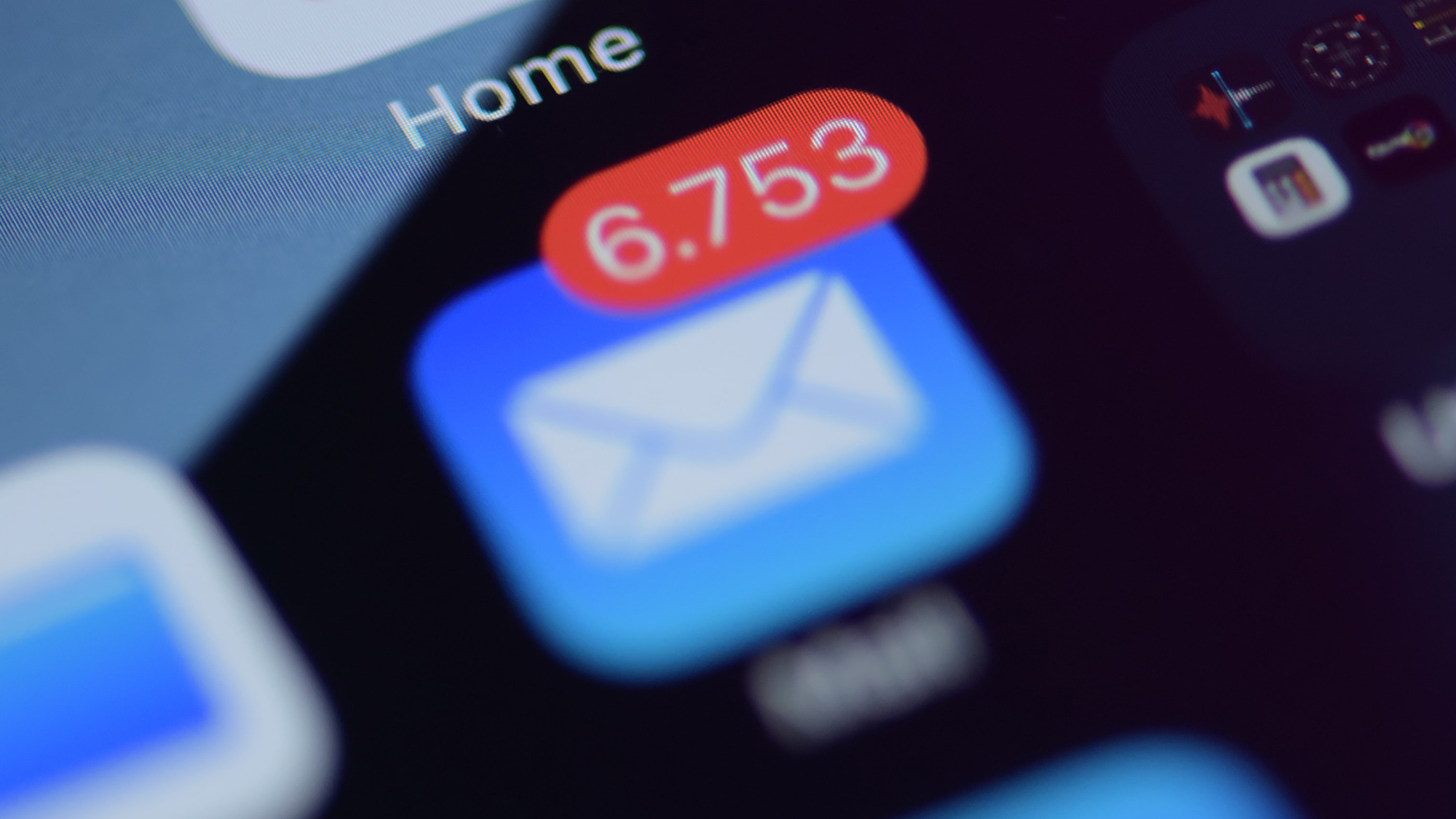 close up of the email app icon on an iphone with a red notification showing 6,753 unread messages