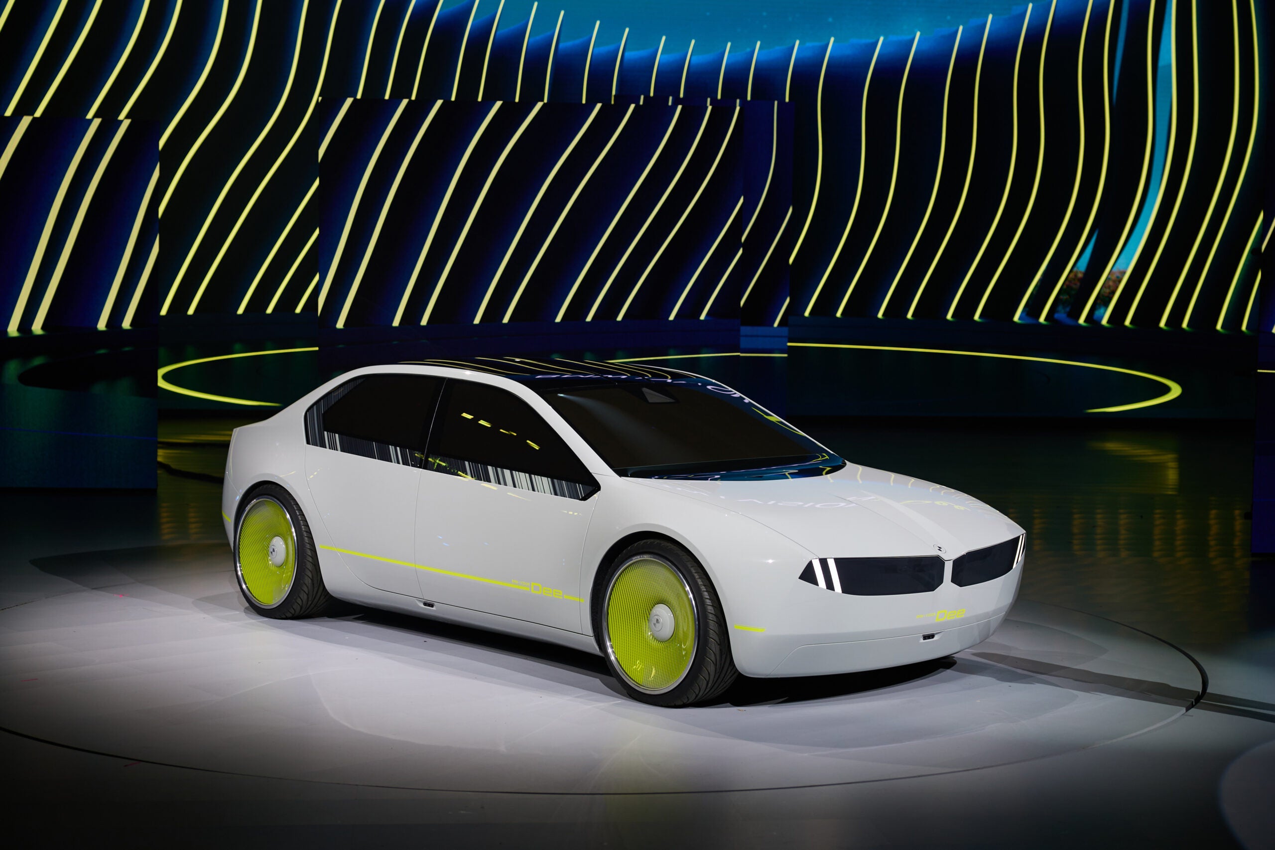 A white Dee BMW electric concept car on a stage