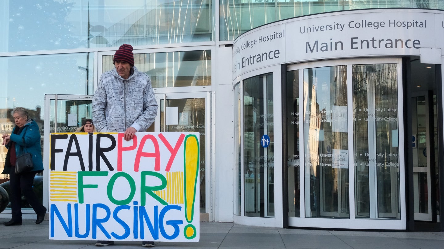 Protesters hold signs in front of University College London Hospital, Euston Road in solidarity with the nurses strike and the NHS on December 20, 2022.