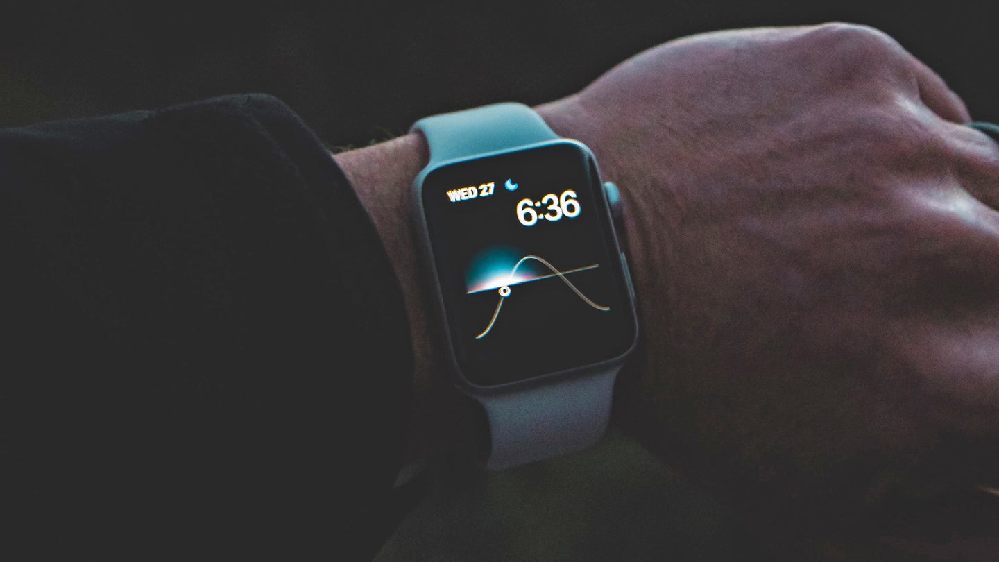 A person wearing a teal Apple Watch on their wrist, perhaps about to open up Maps and get directions to a destination.