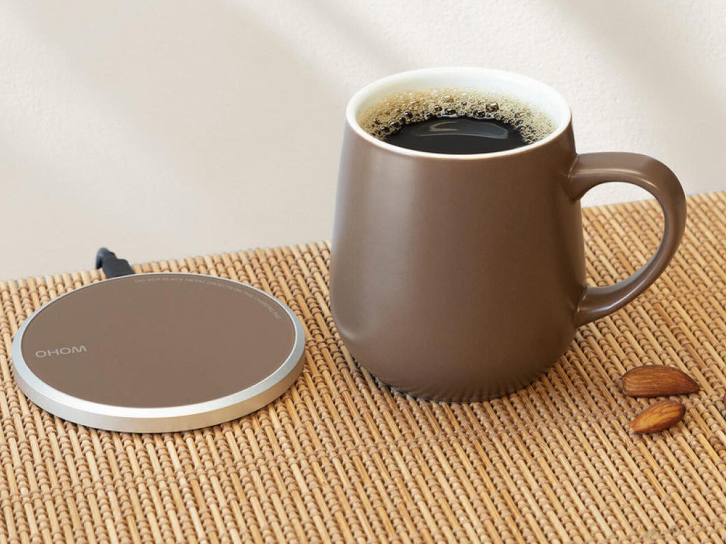 A mug warmer and phone charger on a wooden table
