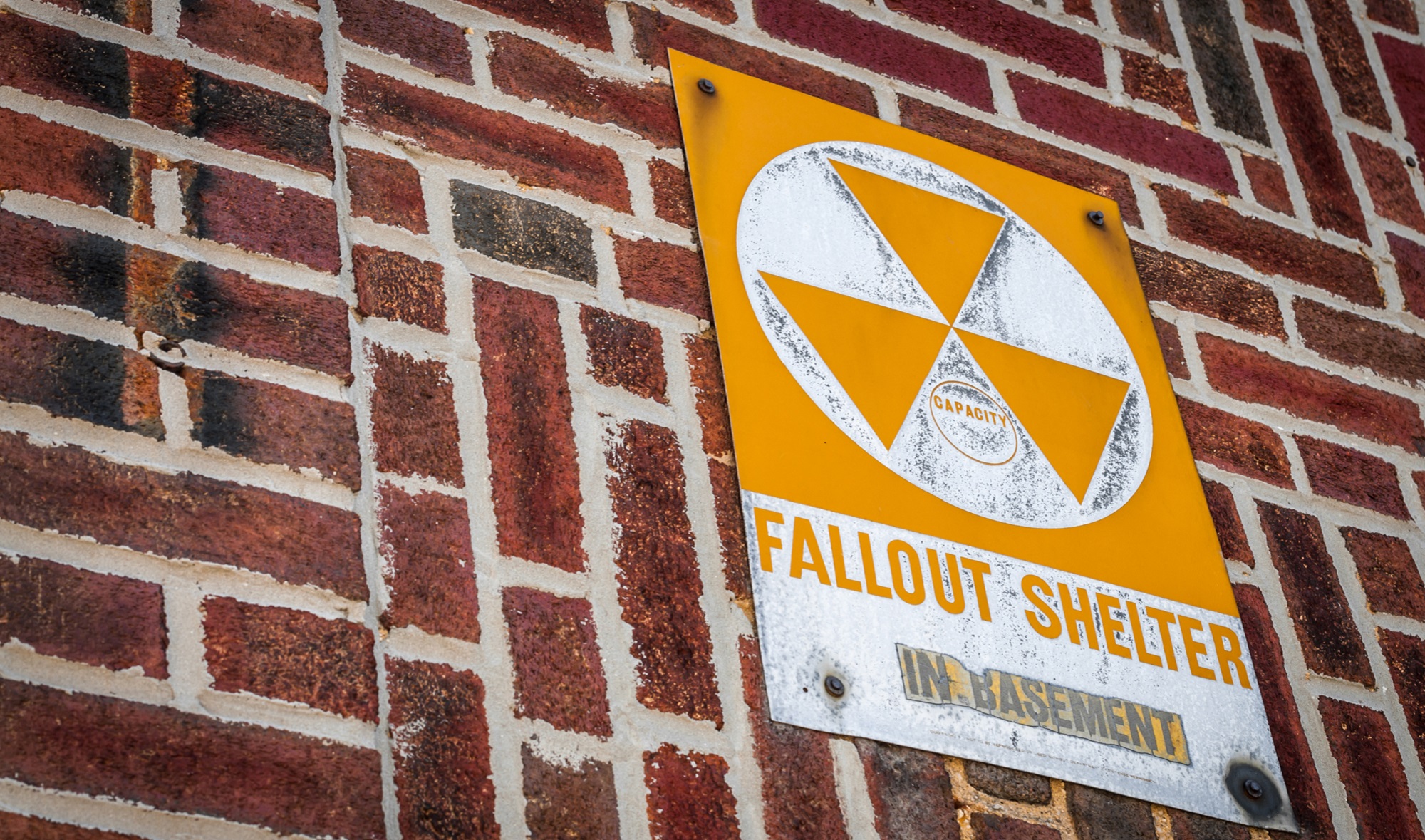 Nuclear shelter basement sign on brick building to represent survival tips for a nuclear blast