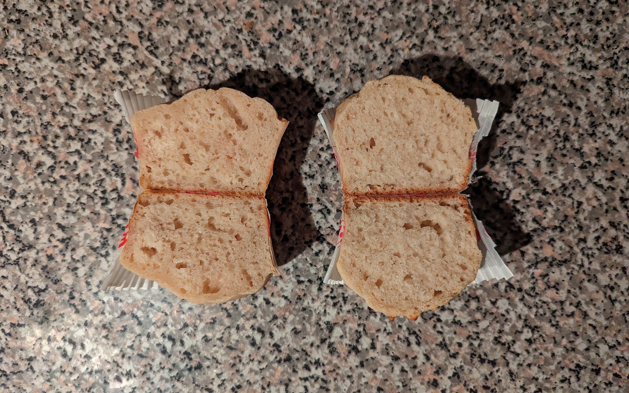 Two muffins cut in half to expose the inner texture of the bake