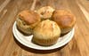 plate with four muffins over kitchen wooden counter