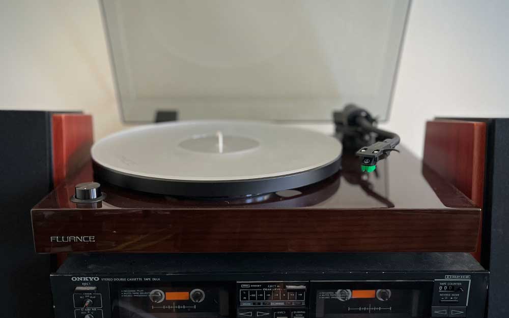 A Fluance RT81+ turntable sitting on a casette deck.