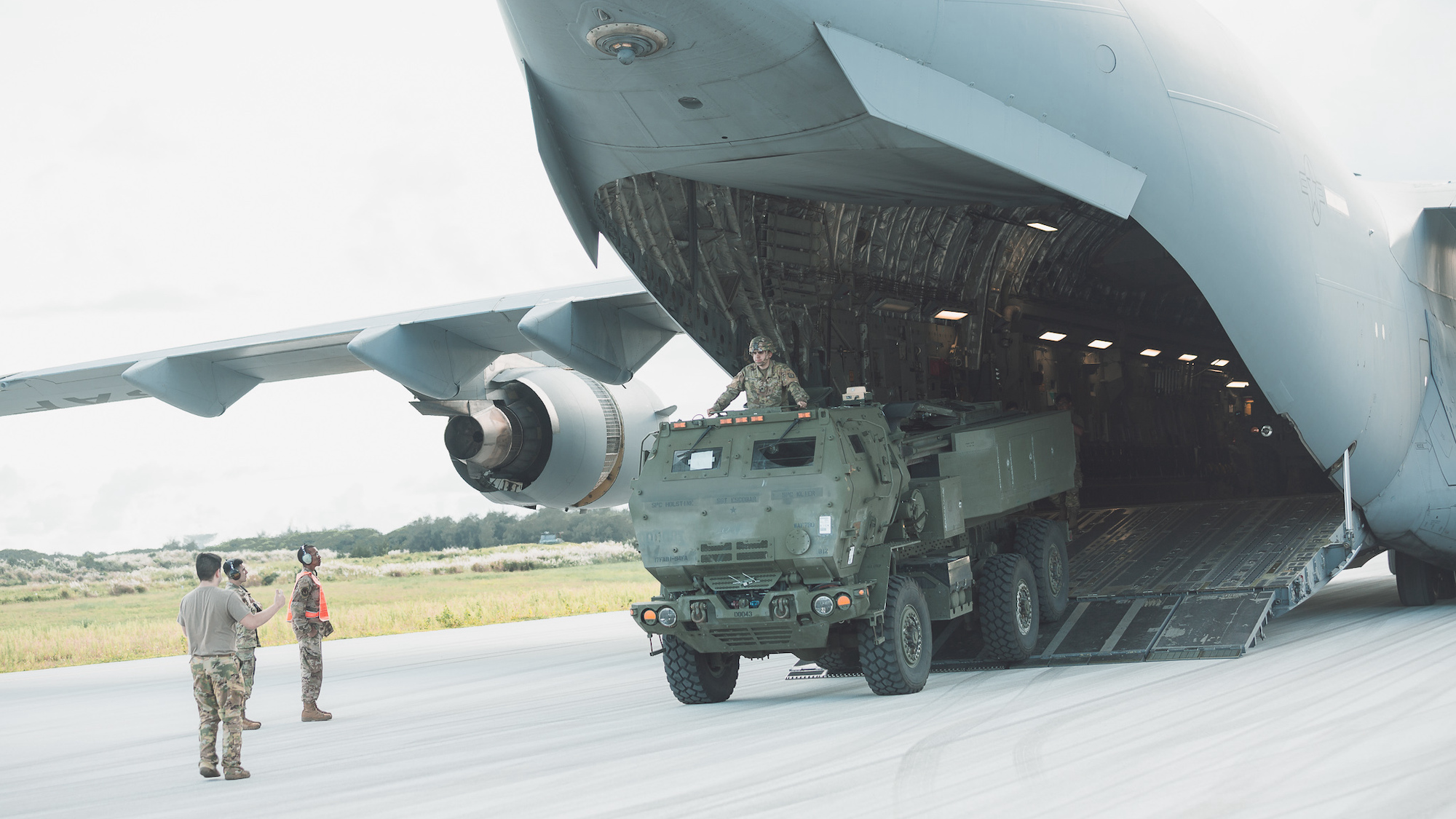 a military vehicle exits an airplane