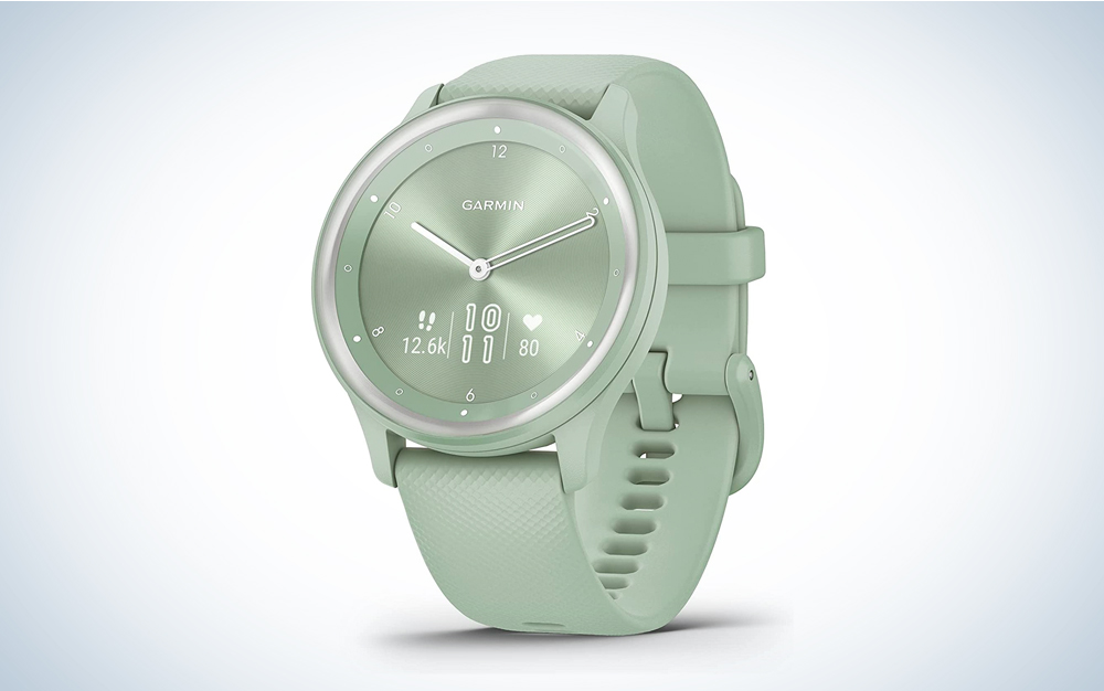 A green Garmin vivomove hybrid sports watch on a blue and white background