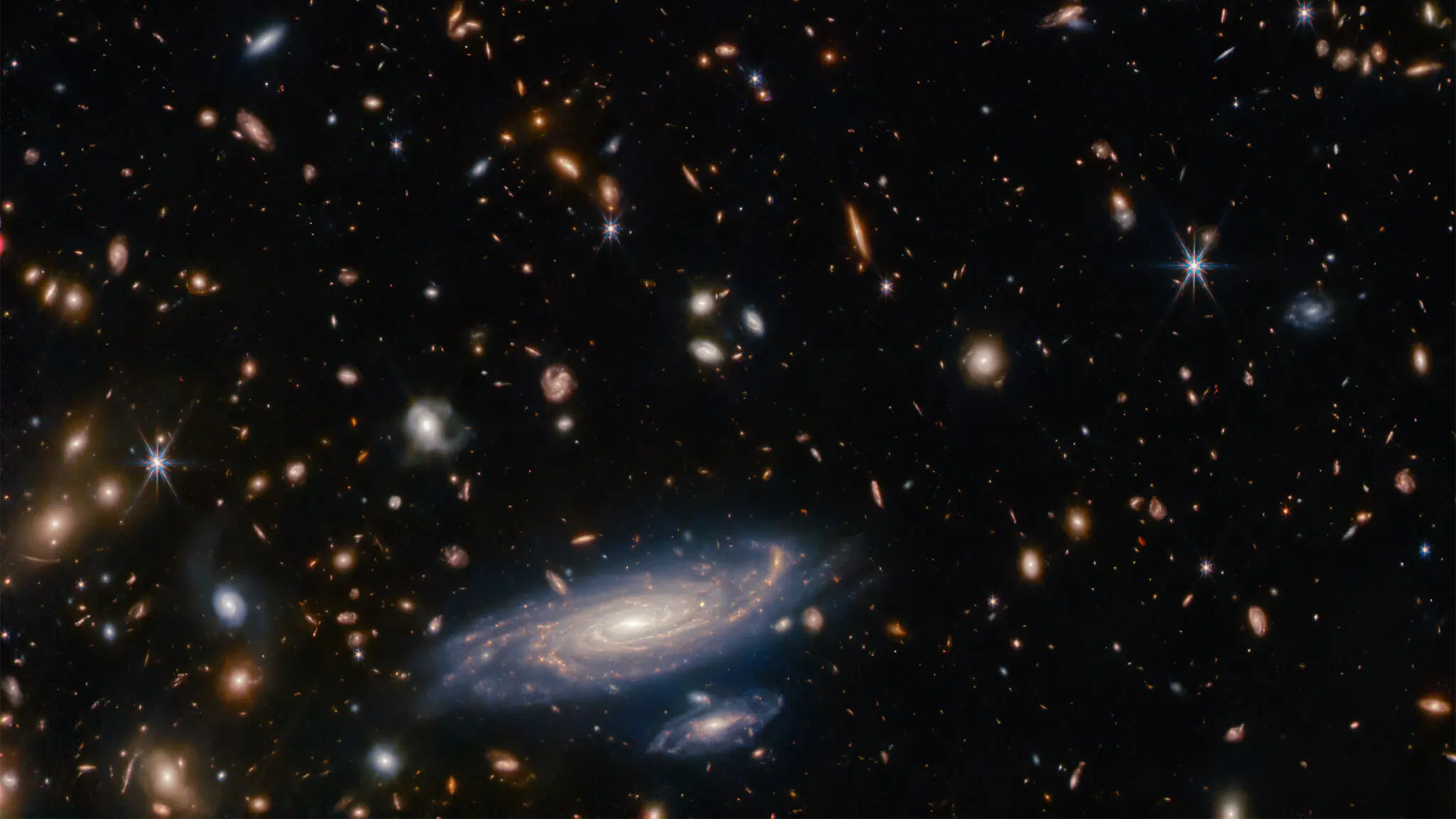 An image captured by the James Webb Space Telescope of stars and galaxies surrounding spiral galaxy LEDA 2046648.