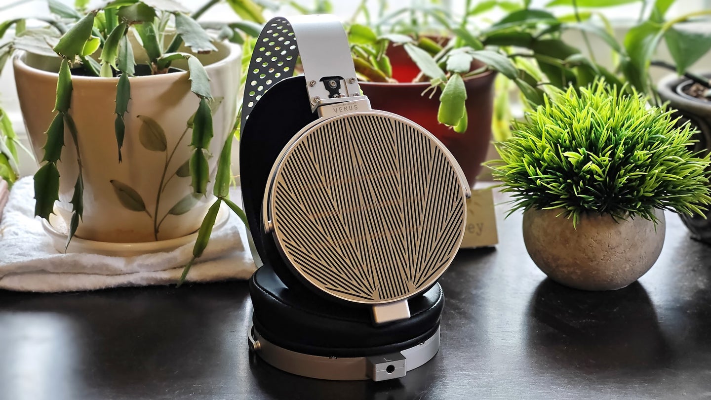 A pair of Moondrop Venus planar-magnetic headphones on a desk surrounded by plants.