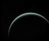 Voyager 2's last image of Uranus, with the gas giant partially obscured in shadow.