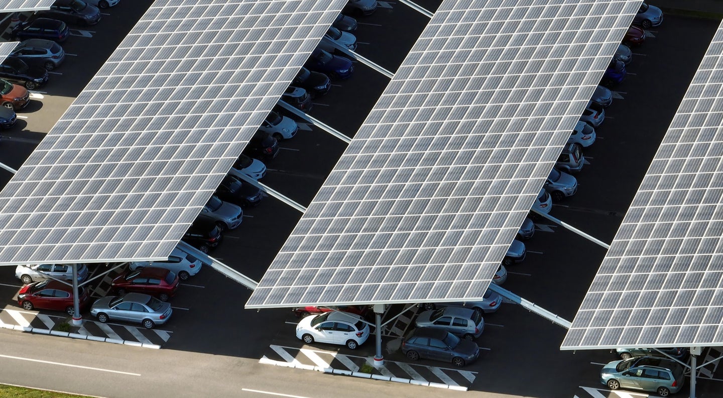 A solar canopy installed above parked cars, as seen from the air.