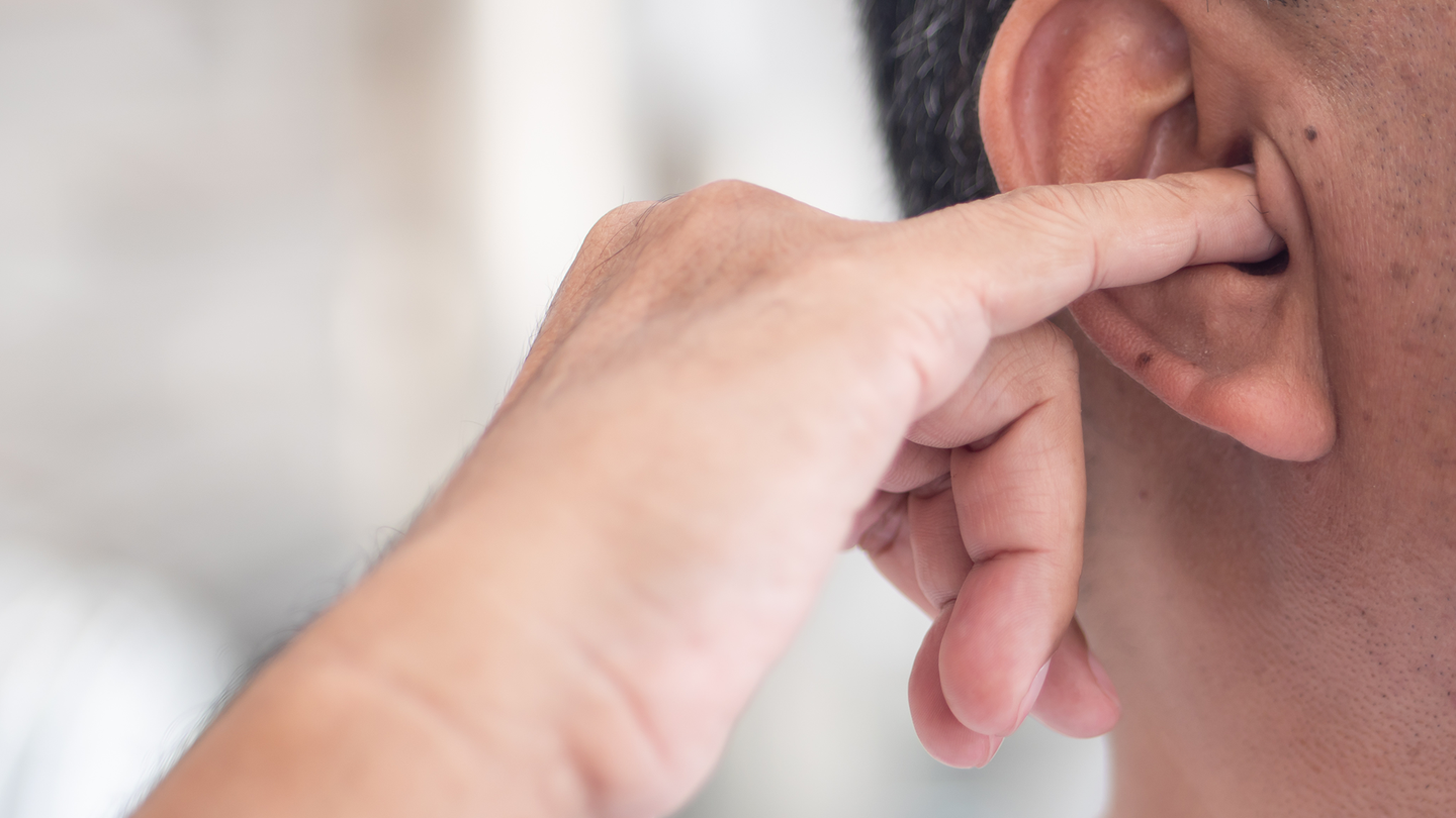 a person putting a finger in their ear