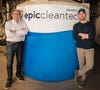 Two men stand in front of large industrial tub labeled epiccleantec
