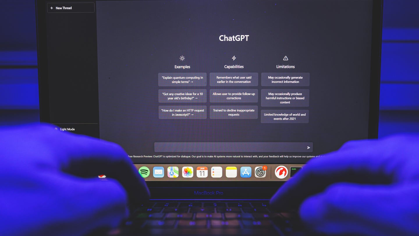 Hands typing on laptop keyboard with screen displaying ChatGPT homepage