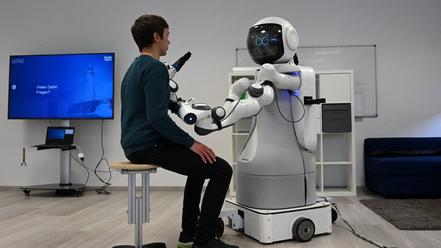 Garmi aid robot attending to seated patient in lab