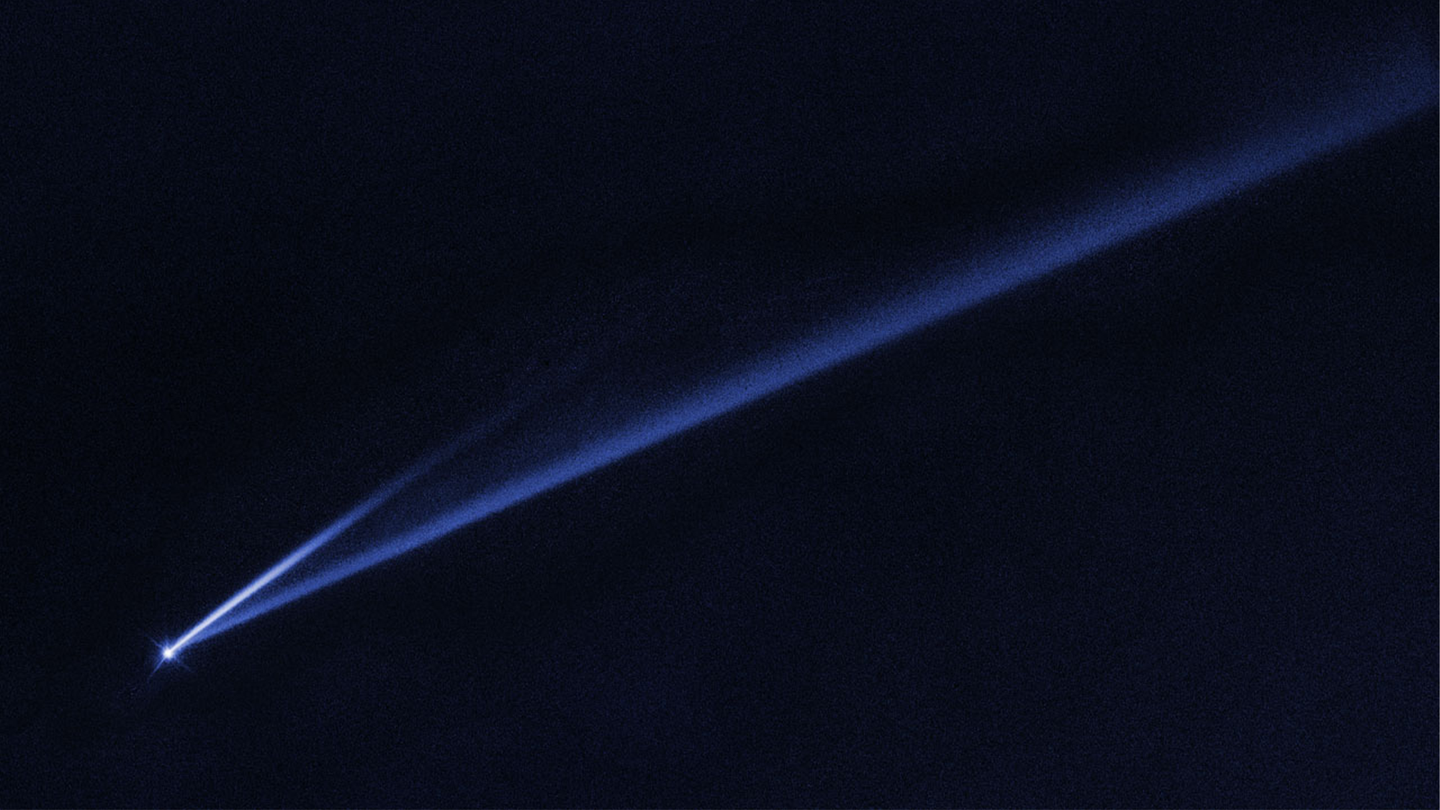 An asteroid comes apart in the night sky.