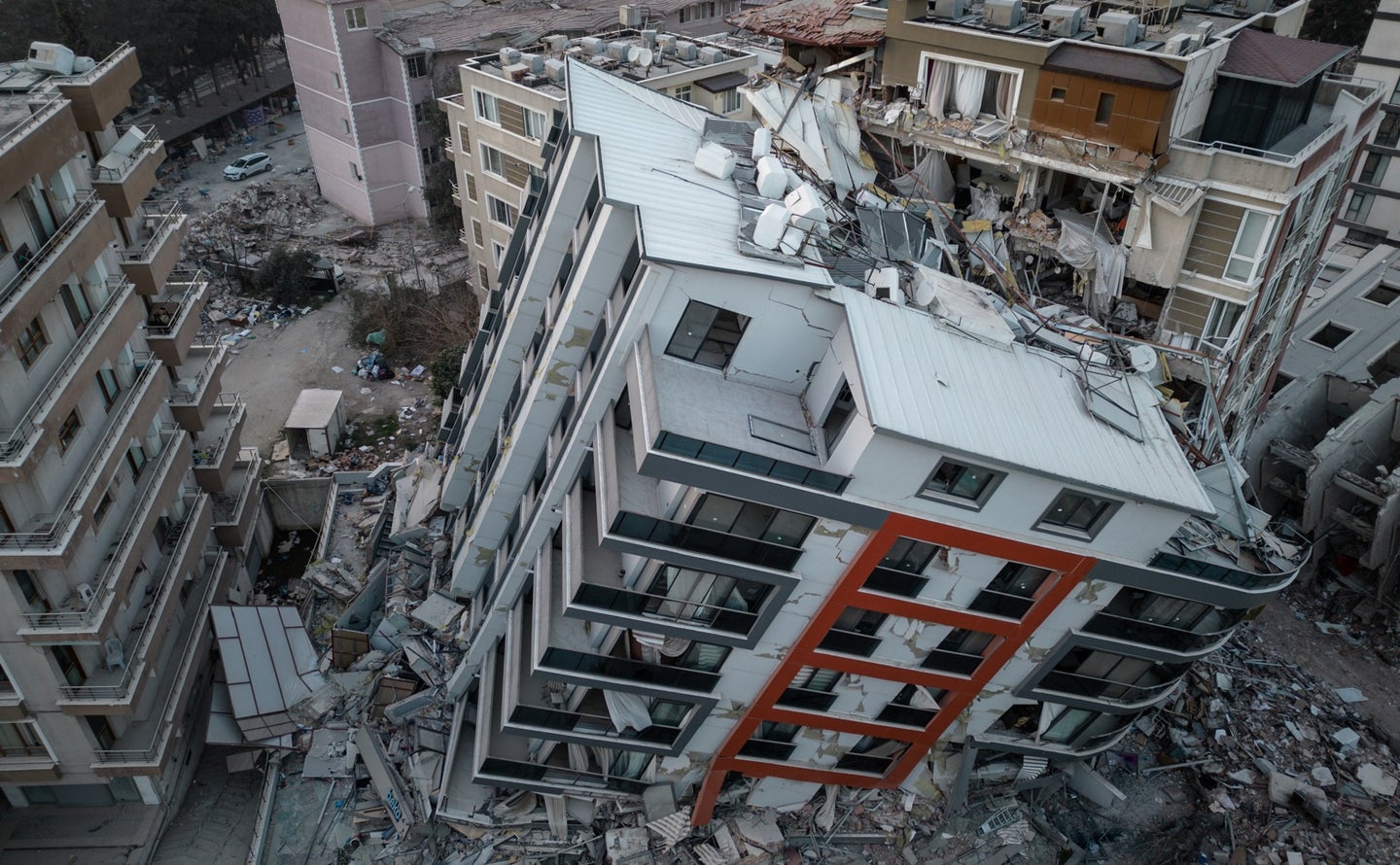 Complete collapse of tall apartment building after Turkey Syria earthquake. Seen from aerial view.