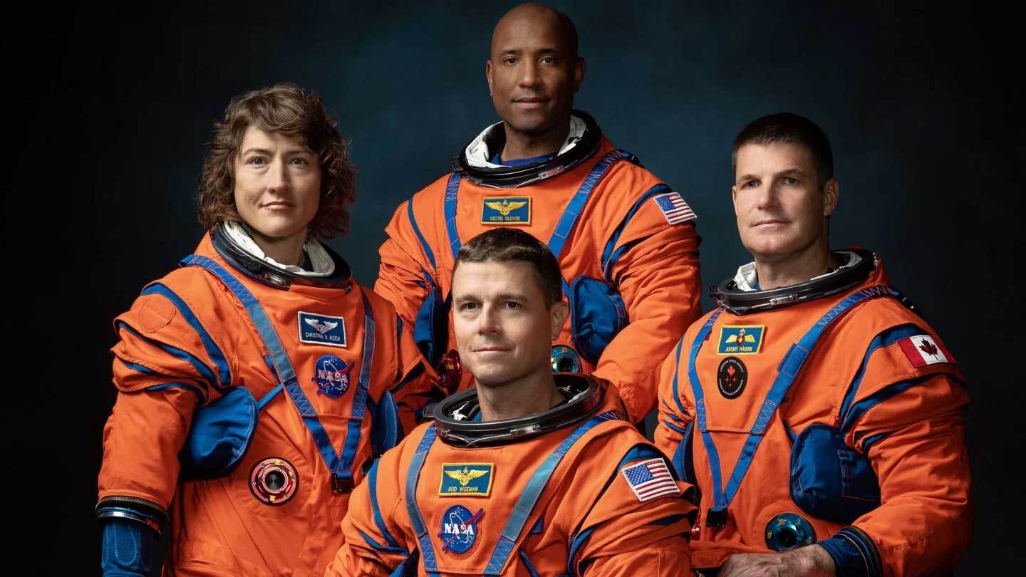 Artemis II astronauts in orange NASA and Canadian Space Agency spacesuits