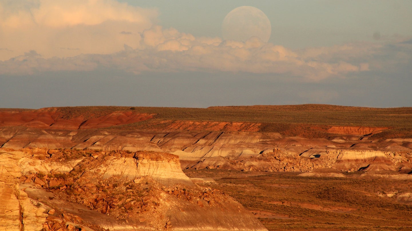 the moon over the red plateaus of the Petrified Forest National Park