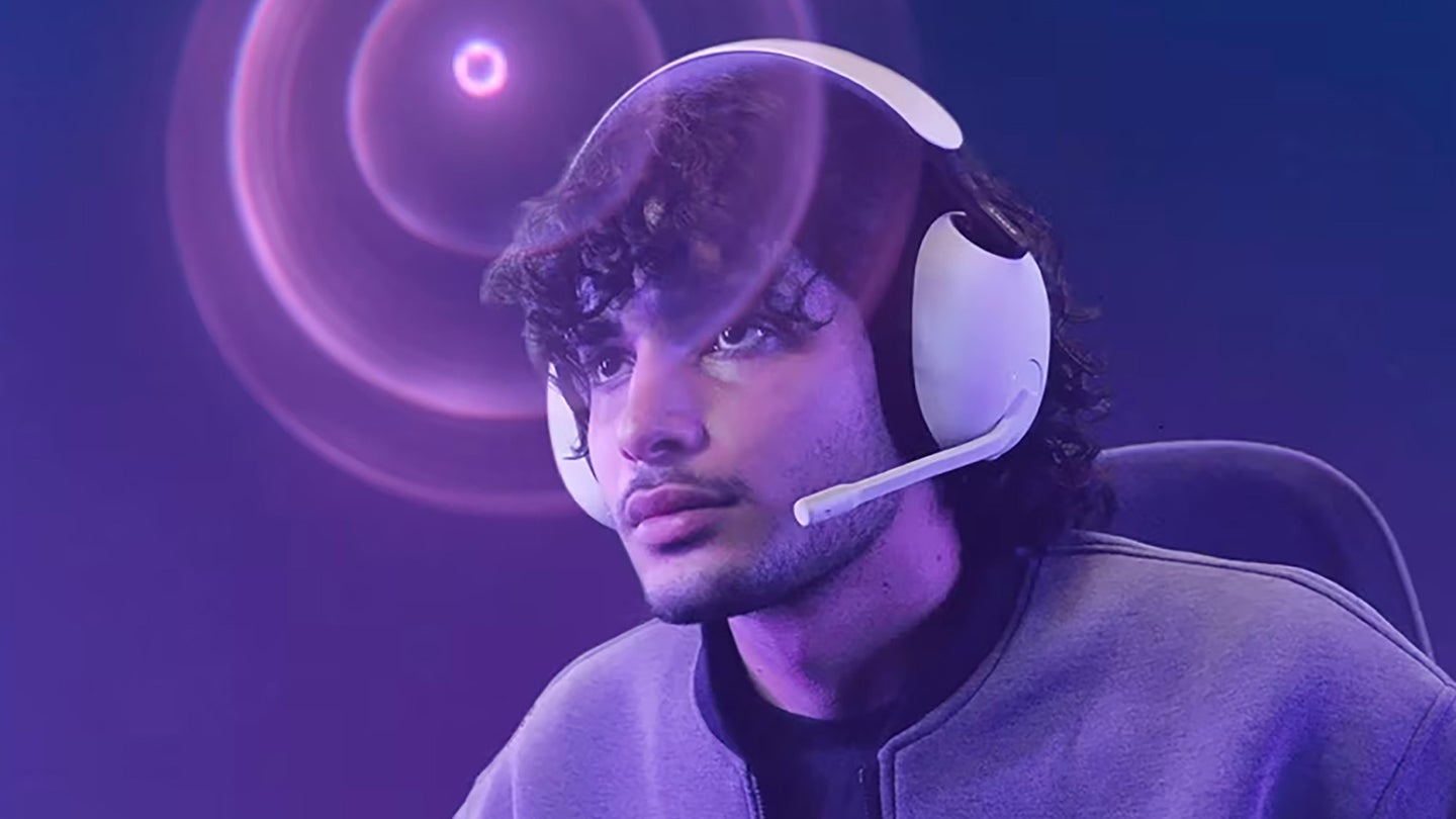 Person wearing official PlayStation headset while gaming against a purple background.