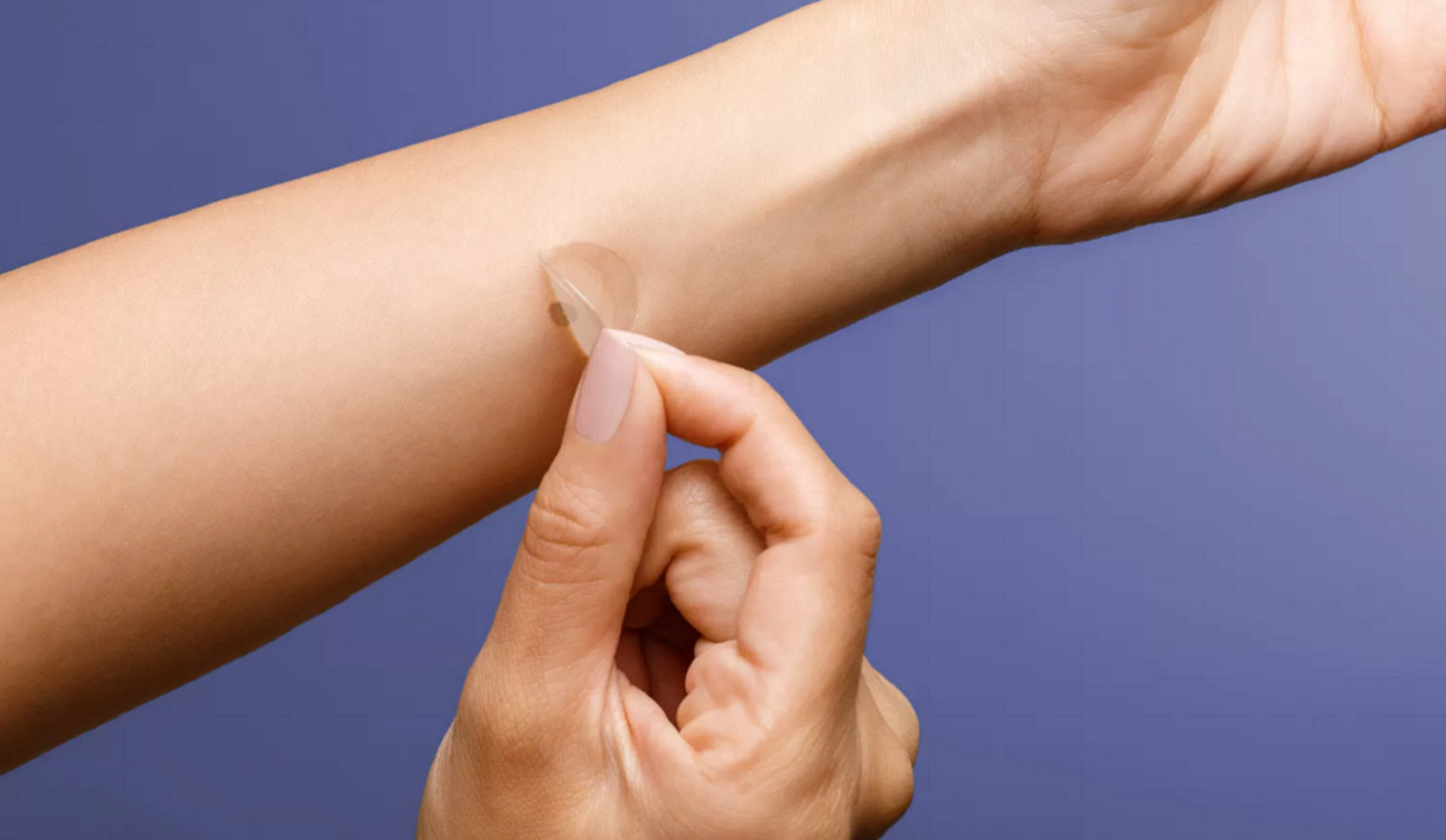 DermTech Smart Sticker skin cancer test on a person with white arms against a purple background