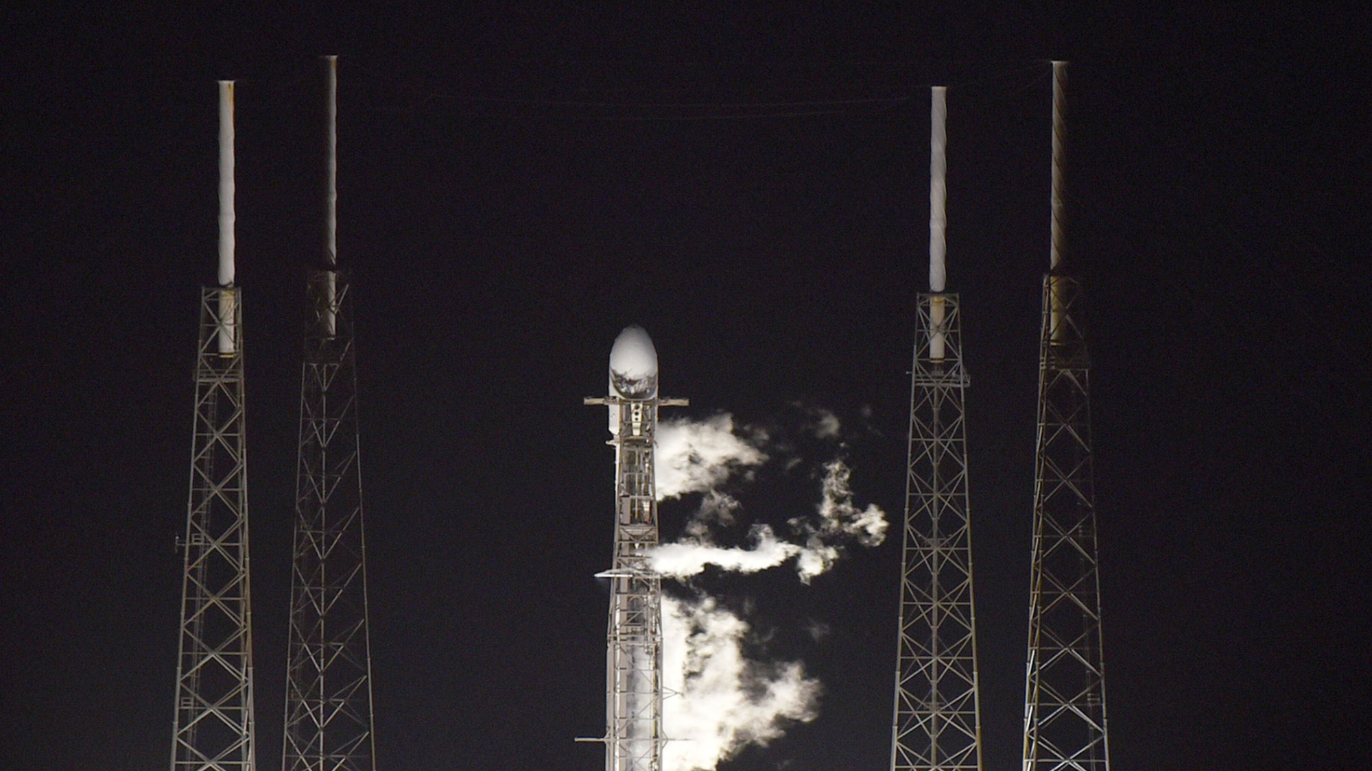 SpaceX Falcon 9 rocket readying for launch at night