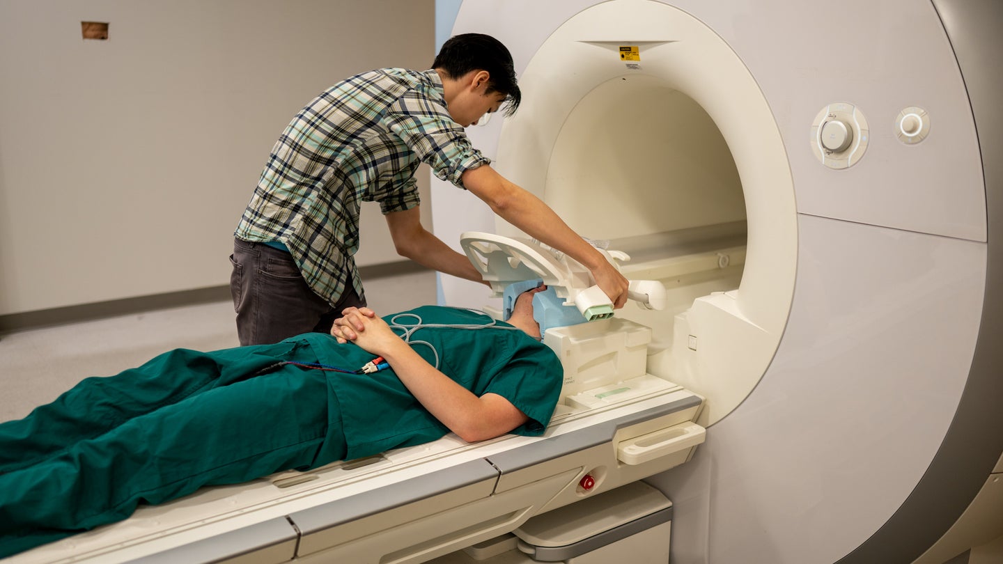 Man prepping person for fMRI scan.