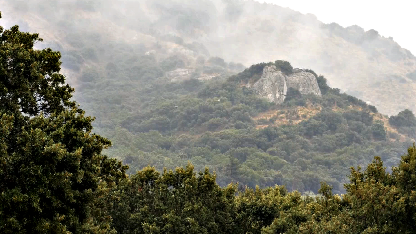 A rock called Grotte Mandrin with a mountain in Mediterranean France. The cave records some of the earliest migrations of Homo Sapiens in Europe.