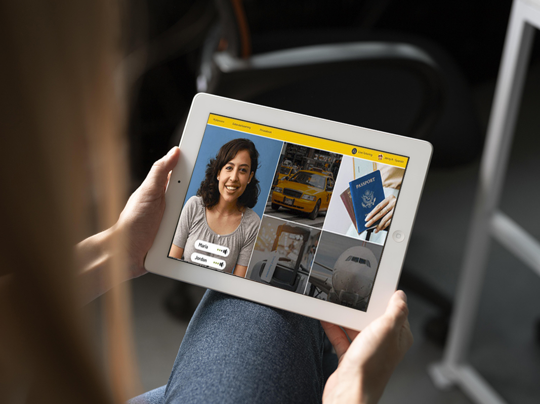 A person holding up an iPad using Rosetta Stone.