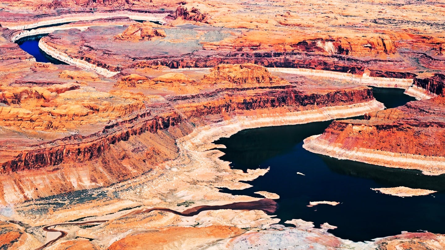 A bathtub ring seen above the waterline o the brown and red rocks around Lake Powell, Utah due to drought that reduced the flow of the Colorado River.
