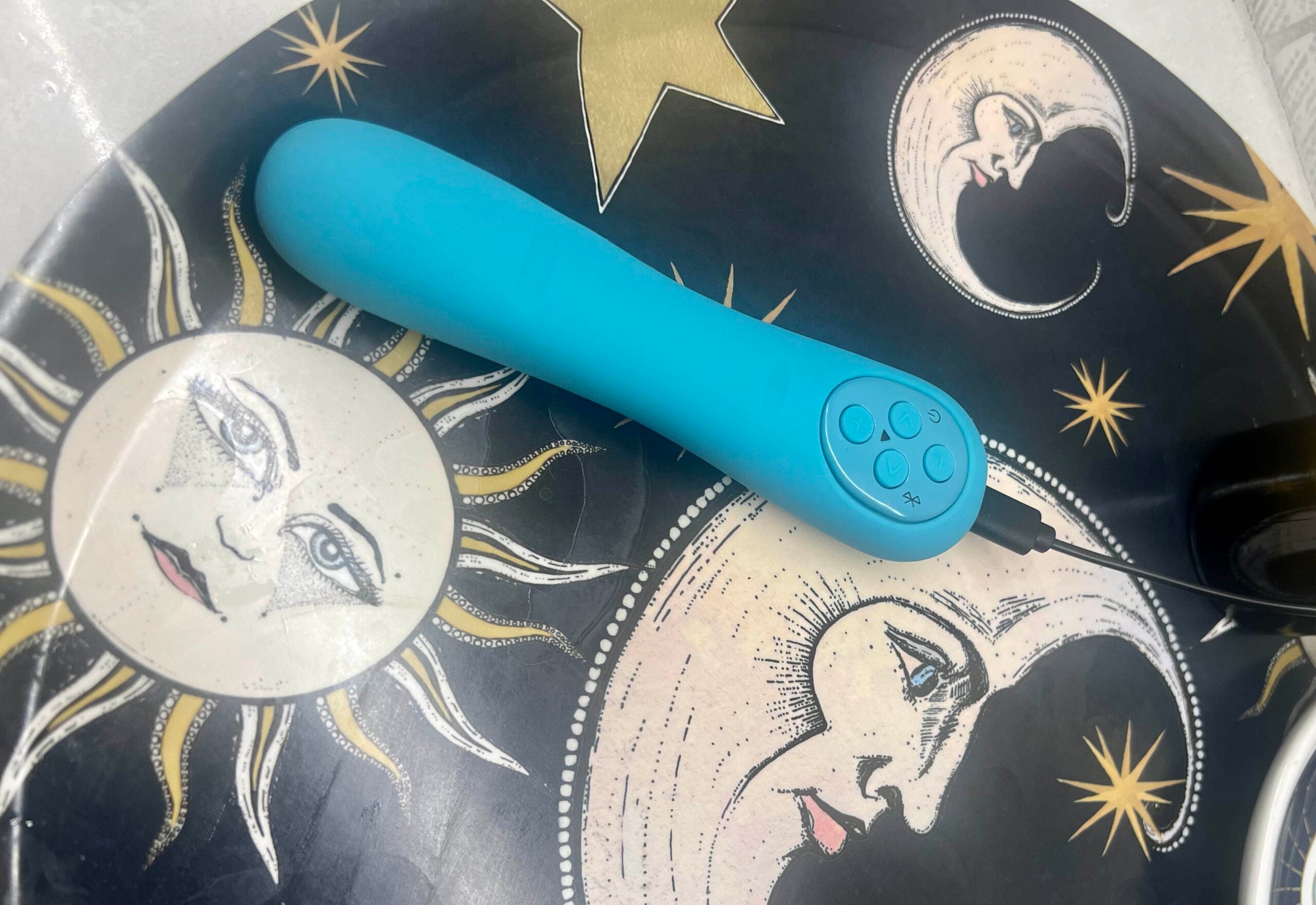teal MysteryVibe Poco on a table with illustrations of the sun, moon, and stars