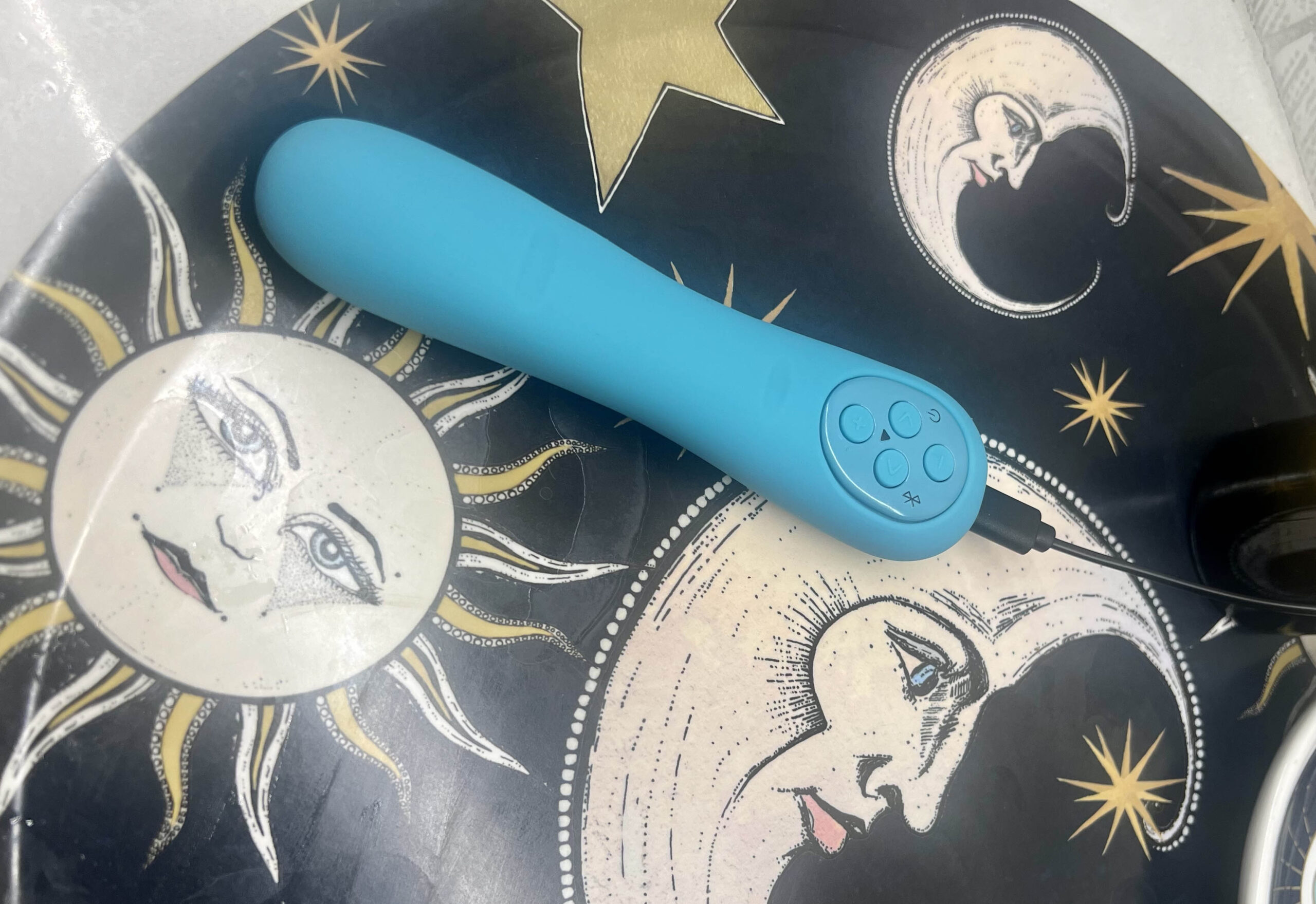 teal MysteryVibe Poco on a table with illustrations of the sun, moon, and stars