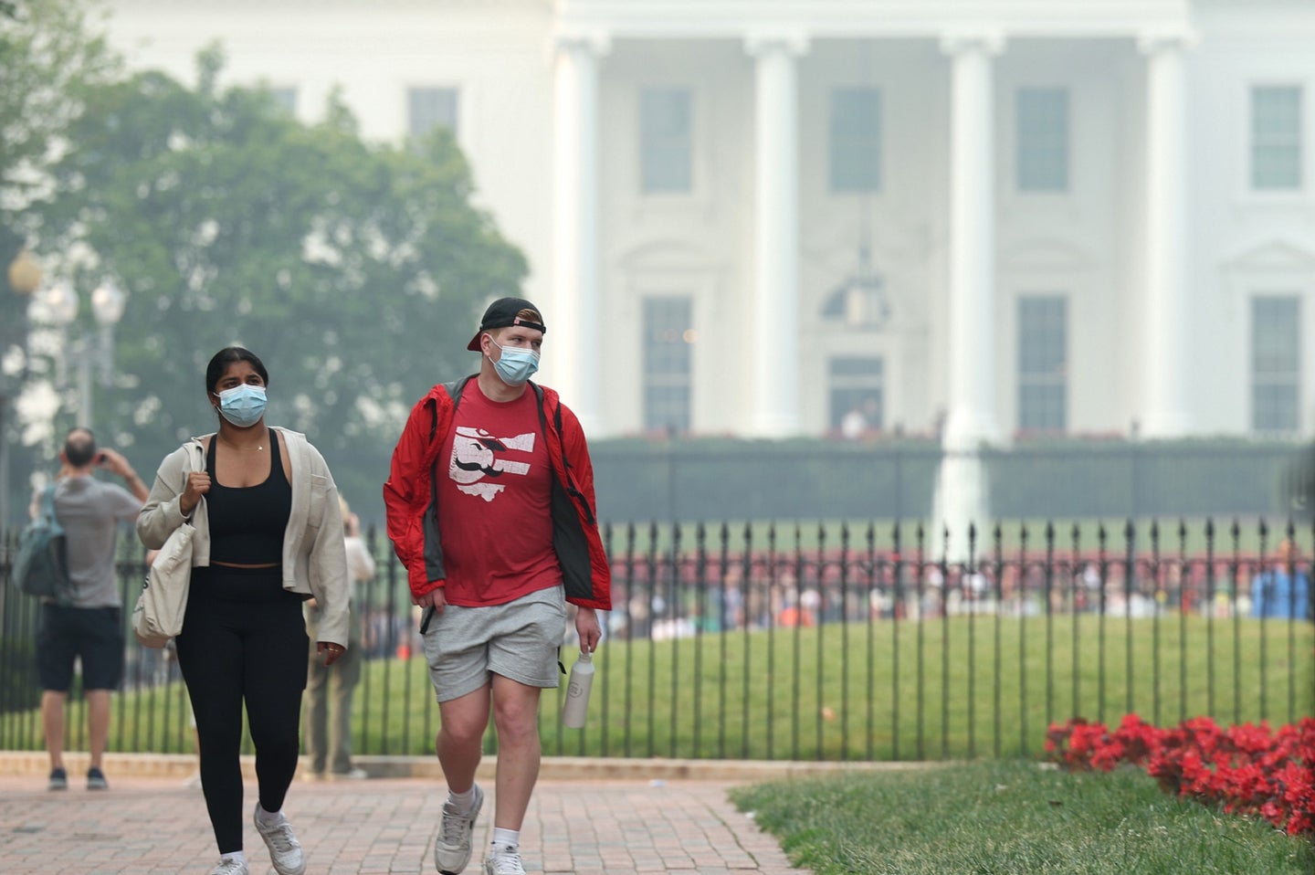 People wearing masks for wildfire smoke and bad air quality in front of White House