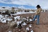 USGS scientist Laura Norman taps snow-covered logs with foot on a ranch in Arizona