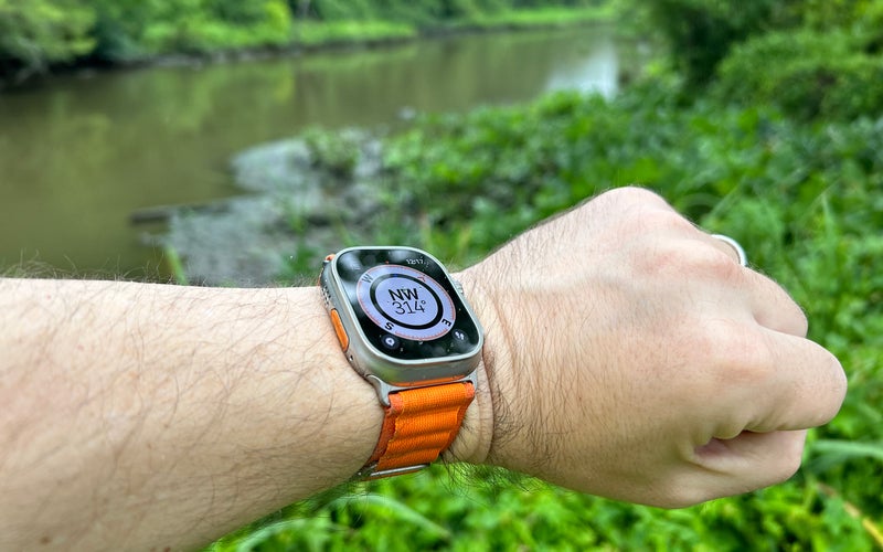 Apple Watch Ultra with an orange alpine loop showing the compass face at the Theodore Roosevelt Island marsh