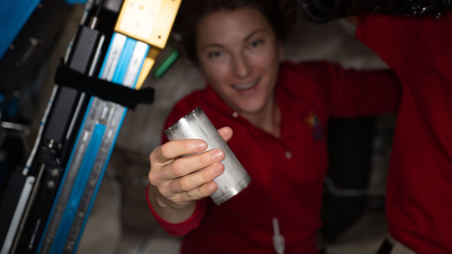 Astronaut on ISS holding up water system filter replacement