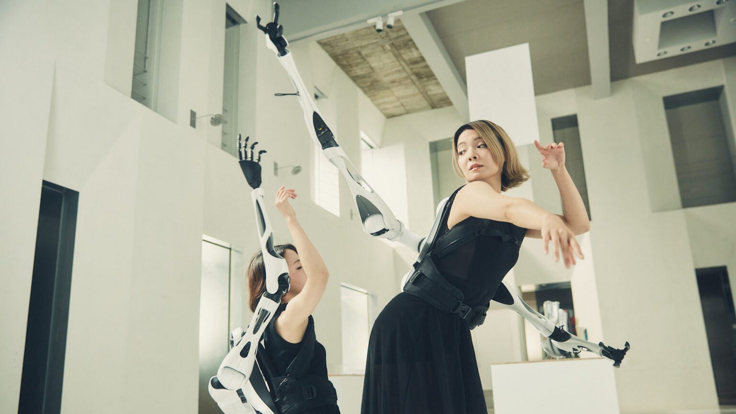 Two dancers wearing Jizai Arms wearable robotic appendagees