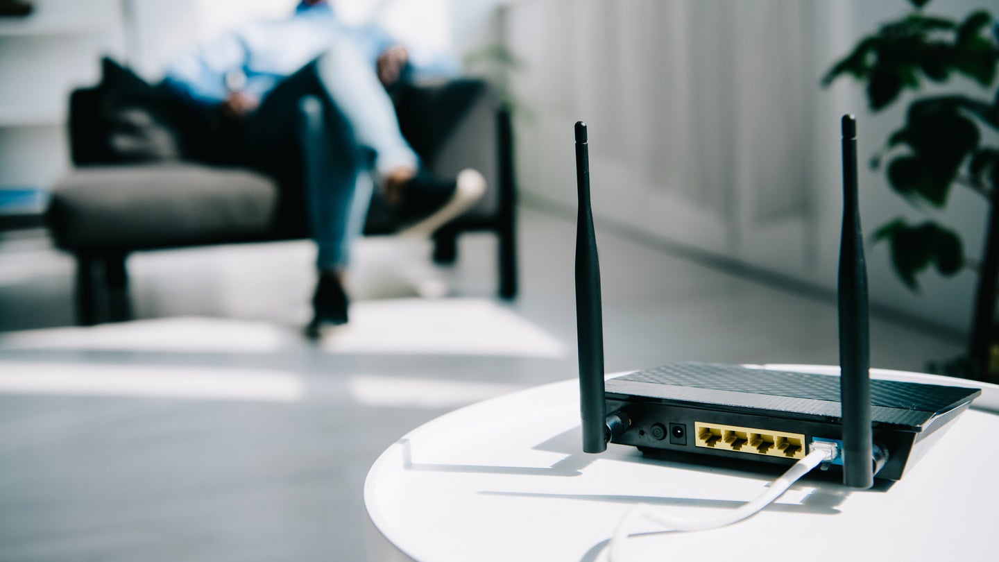 Internet router on table with man sitting on couch in background