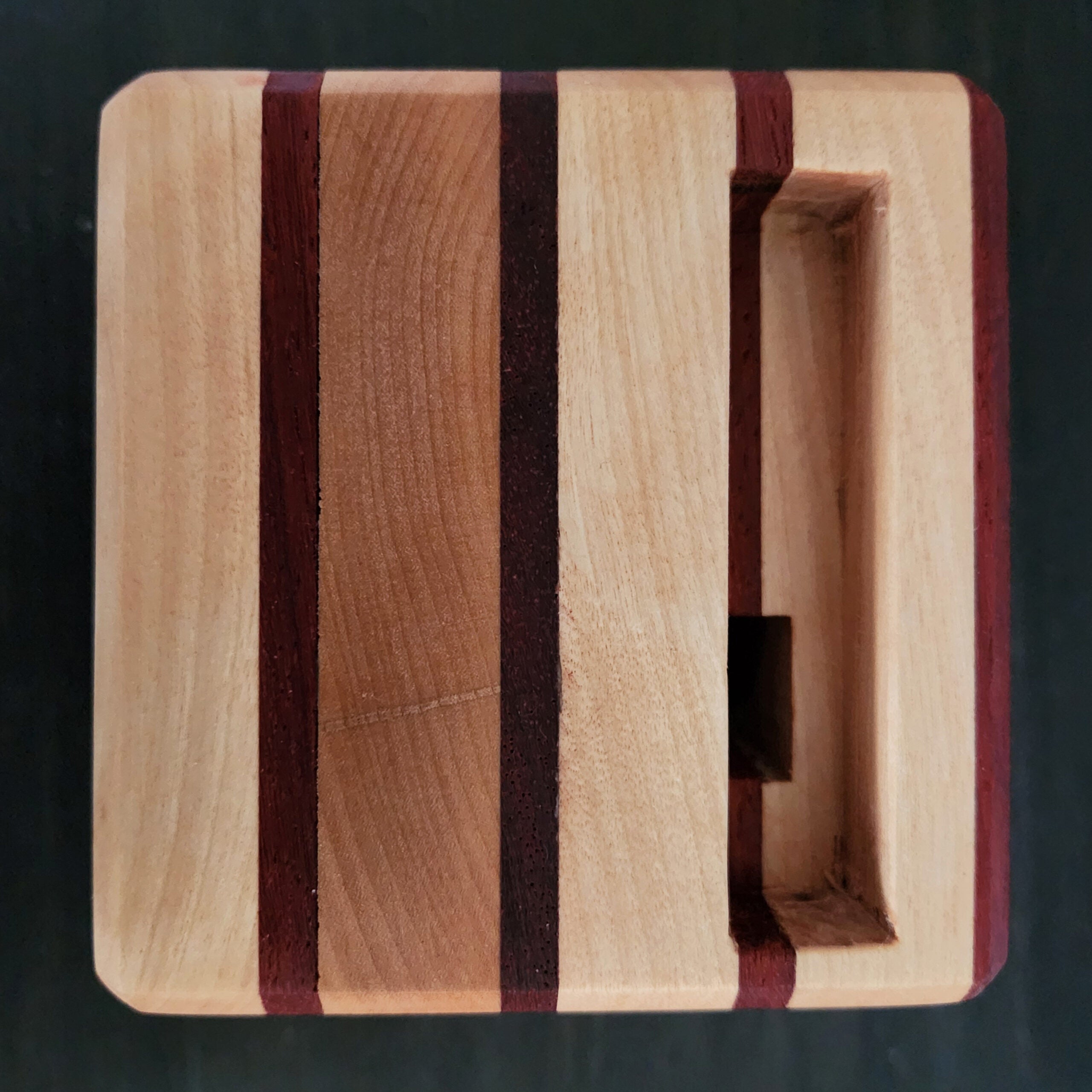 A top-down view of a passive wooden phone amplifier, showing the slot for the phone and the hole that sends the audio into the main speaker cavity.