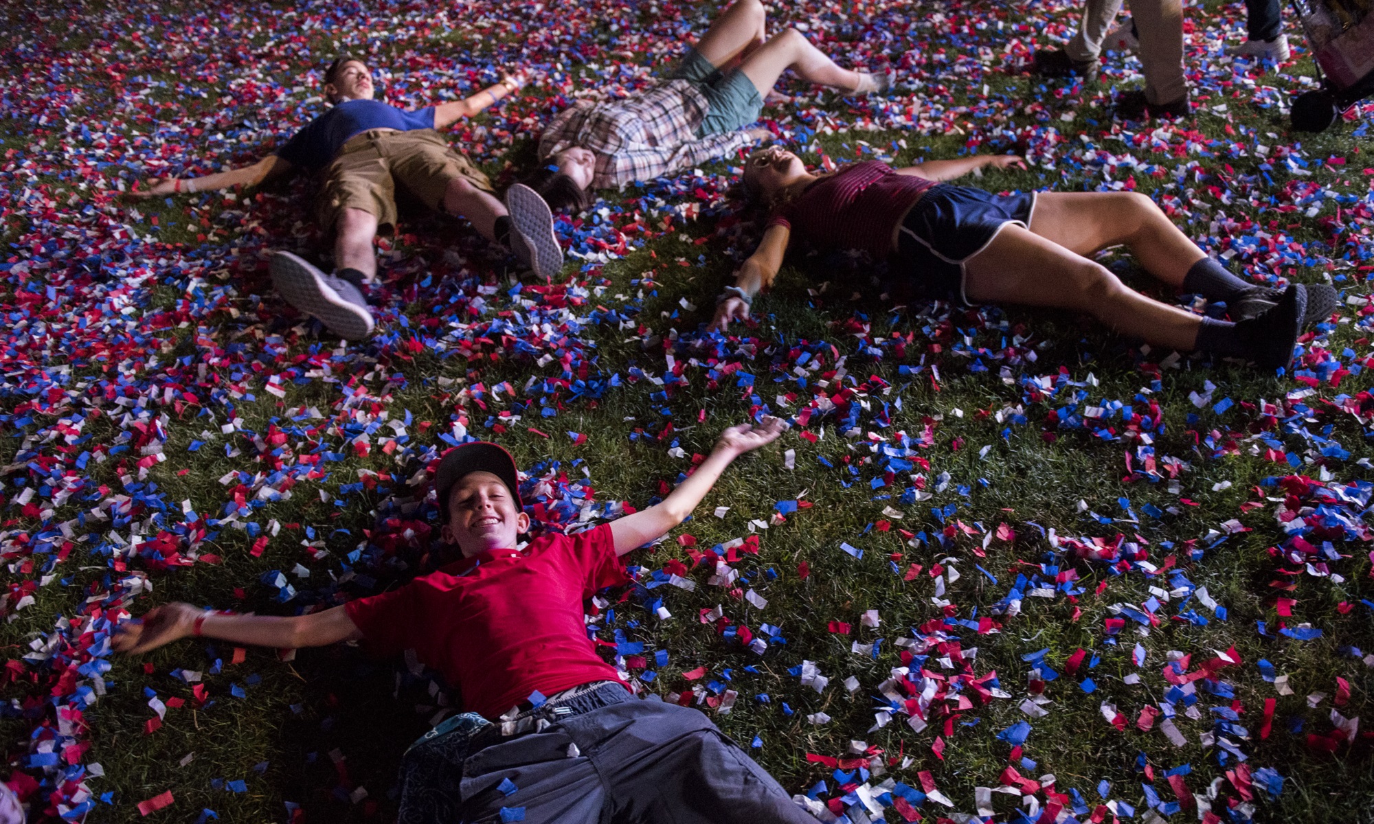 Fourth of July partygoers playing in red, white, and blue confetti, which could be a fireworks alternative