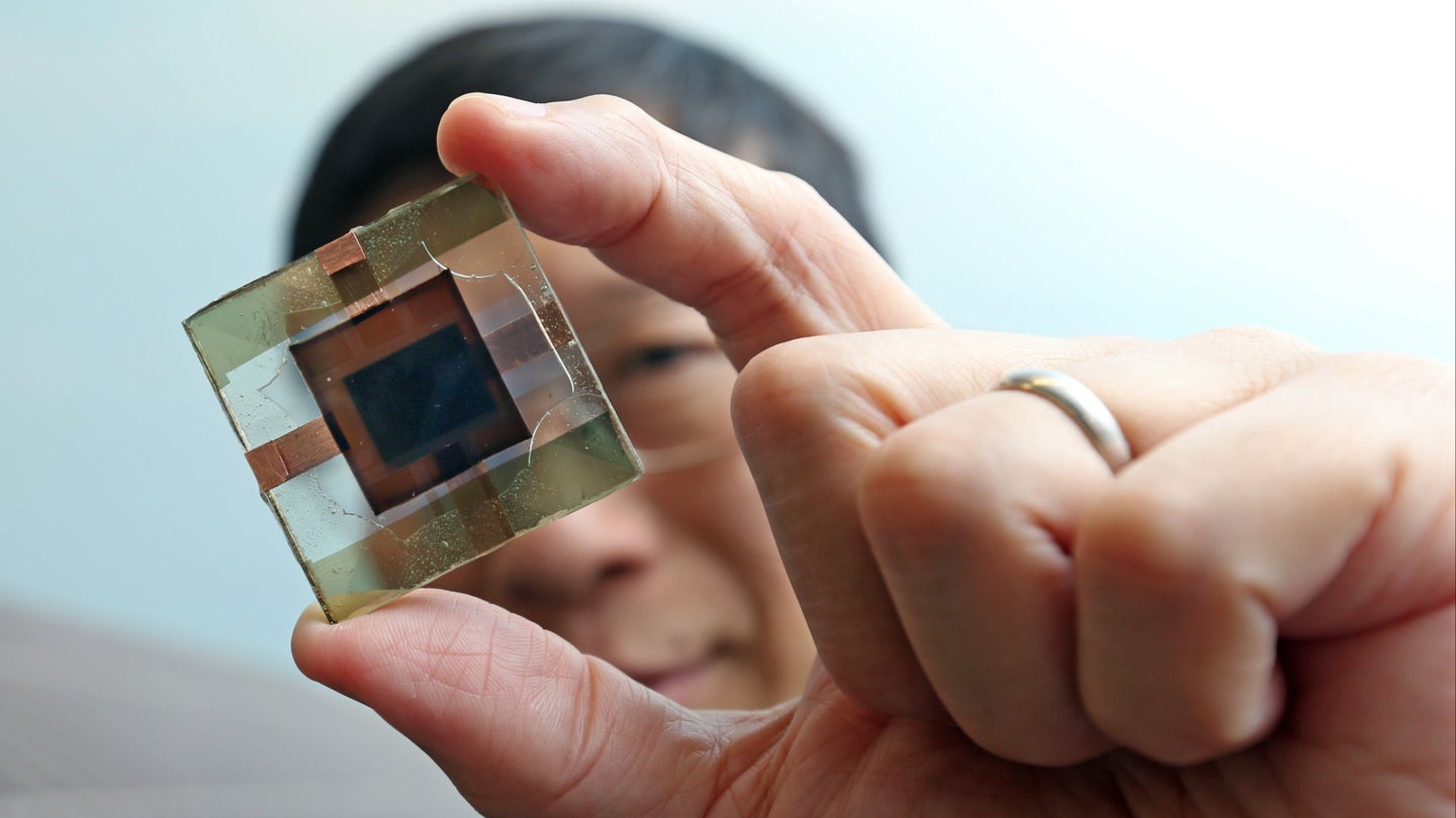 Charles Chee Surya holding perovskite/silicon solar cell.